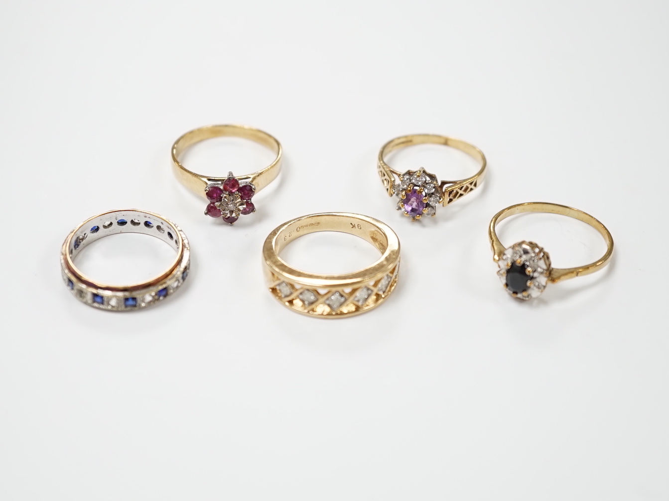 Five assorted modern 9ct gold and gem set dress rings including ruby and diamond cluster and six stone diamond set half hoop, gross weight 14.4 grams.